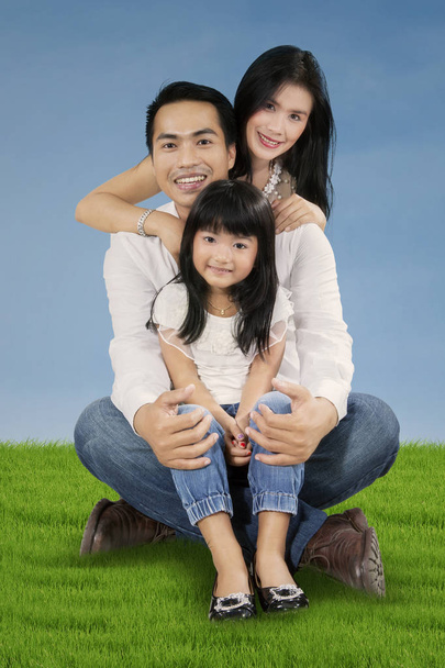 Cheerful family sit on the green grass - Photo, Image