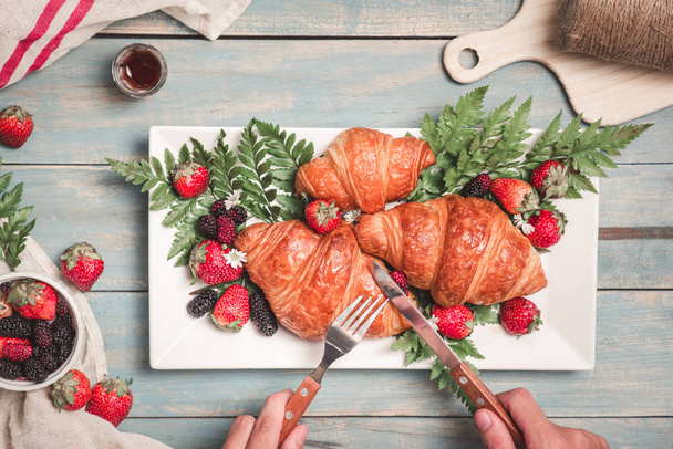 Desayuno con croissants y fresa sobre mesa de madera azul. V.
 - Foto, imagen