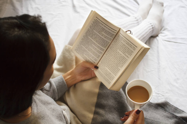 Dziewczyna, czytanie książki i picia kawy w łóżku rano - Zdjęcie, obraz