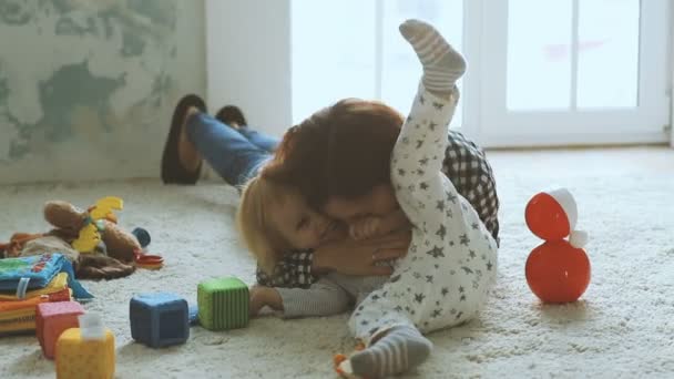 Mother plays with daughter on the floor - Footage, Video