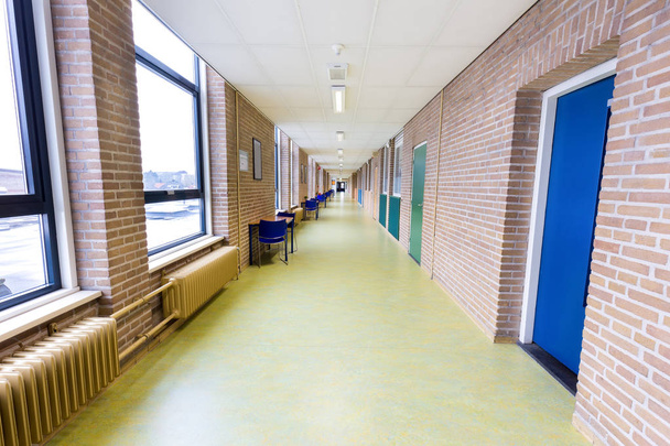 Lang leeg corridor in middelbare schoolgebouw - Foto, afbeelding