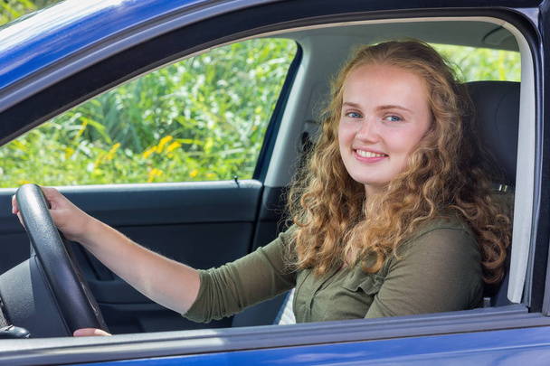 Nuori valkoihoinen nainen ajaa autoa
 - Valokuva, kuva