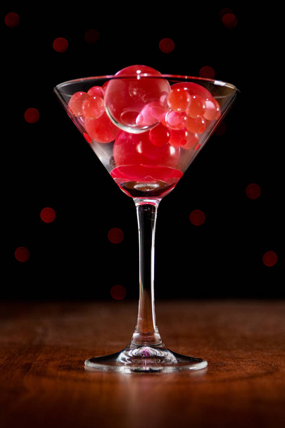 Christmas card: martini glass with balls on bokeh background in  - Foto, Imagem