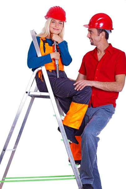 Portrait of smiling couple posing on white background on ladder - Photo, Image