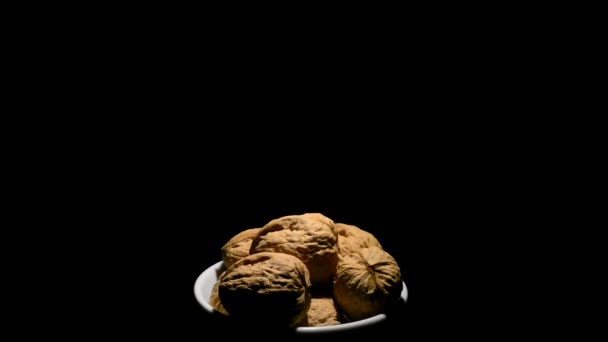 Vlašské ořechy v misce v rotaci na černém pozadí - Záběry, video