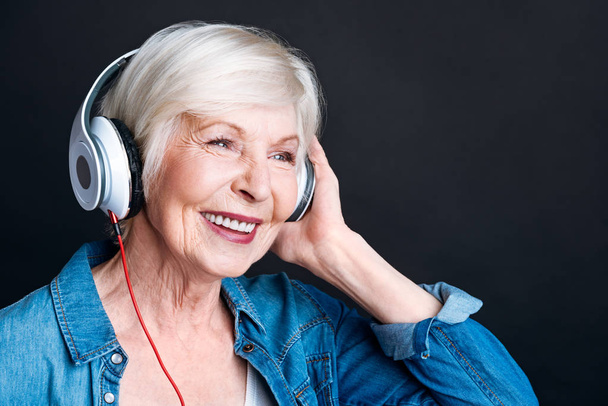 Delighted aged woman listening to music - Φωτογραφία, εικόνα