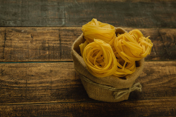Dry pasta on wooden table - Fotografie, Obrázek