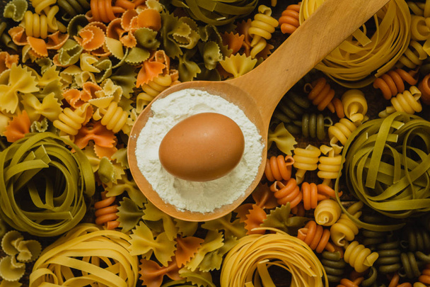 colored pasta with egg in spoon - 写真・画像