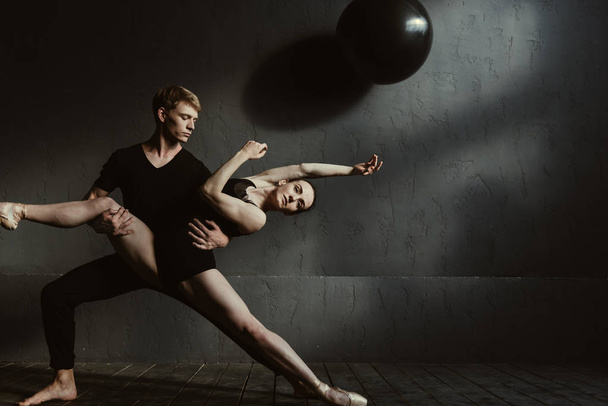 Flexible pleasant gymnasts stretching in interaction with each other - 写真・画像