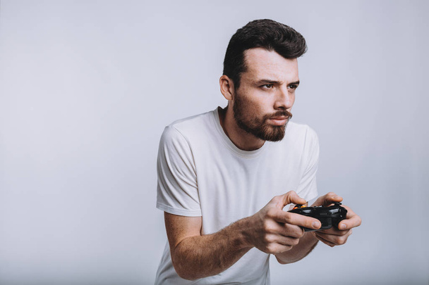 Young guy with beard holding joystick pretending he is playing games - Foto, Imagem