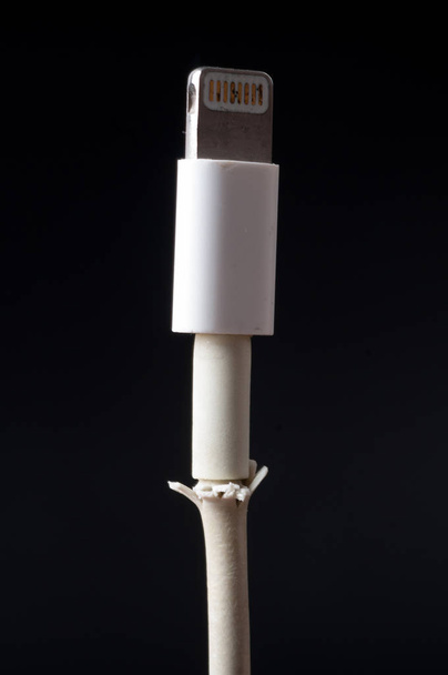 Zbliżenie uszkodzony Smart telefonu kabel ładowarki na czarnym tle - Zdjęcie, obraz