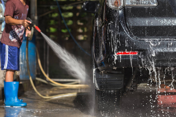 Man spraying pressure washer for car wash in car care shop. Focu - Foto, immagini