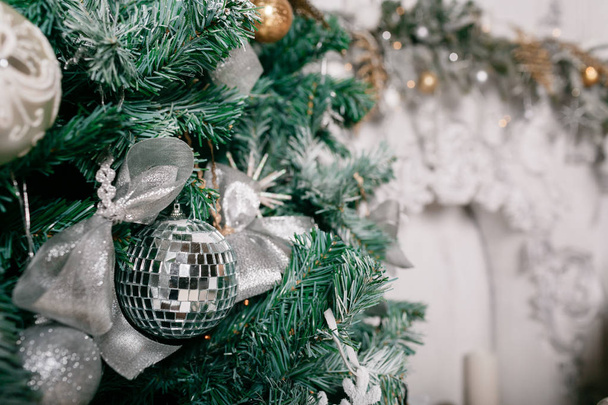 decorative disco ball close-up. Decorated Christmas tree on blurred, sparkling fairy background - Zdjęcie, obraz