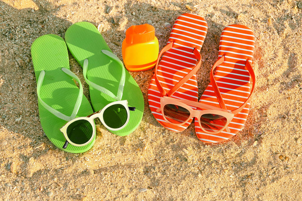 Sunglasses with sandals and sunscreen cream  - Фото, изображение