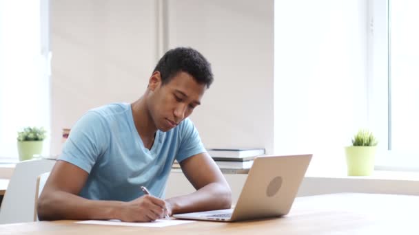 Joven hombre negro escribiendo sobre papel, papeleo
 - Imágenes, Vídeo