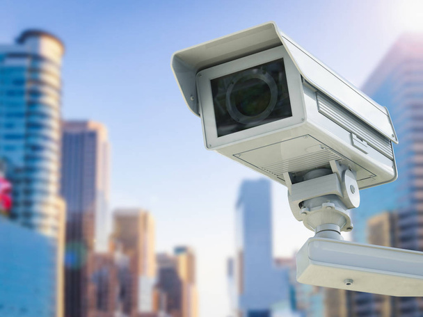 CCTV-kamera tai valvontakamera kaupunkimaiseman taustalla
 - Valokuva, kuva