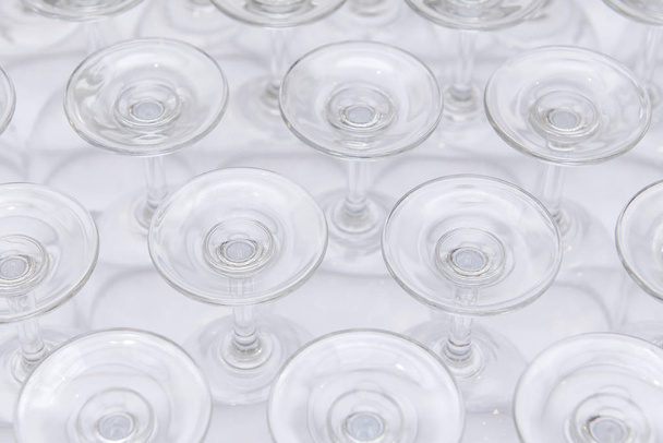 rows of Empty wine glass bottoms on white table - Fotó, kép