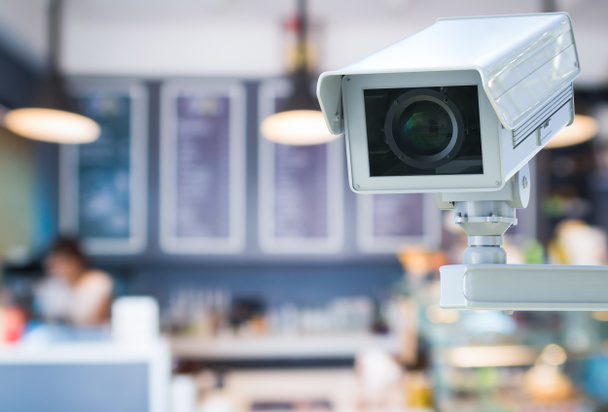 CCTV-kamera tai turvakamera vähittäiskaupan hämärtyneellä taustalla
 - Valokuva, kuva