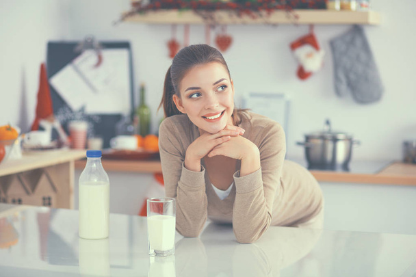 Smiling attractive woman having breakfast in kitchen interior - Valokuva, kuva