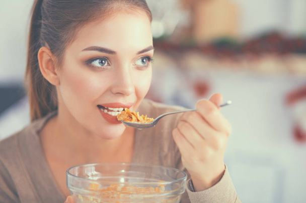 Smiling attractive woman having breakfast in kitchen interior - Фото, зображення