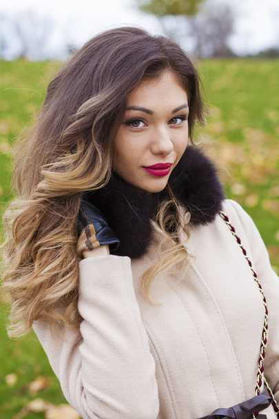 Portrait of a young beautiful woman in beige coat  - Photo, image
