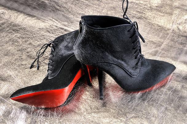  Γυναικείες μπότες χειροποίητο σε ένα κομμάτι του υλικού από το Χρυσόμαλλο δέρμα. Απομίμηση μάρκας Παπούτσια Christian Louboutin, δείχνοντας κόκκινες σόλες - Φωτογραφία, εικόνα