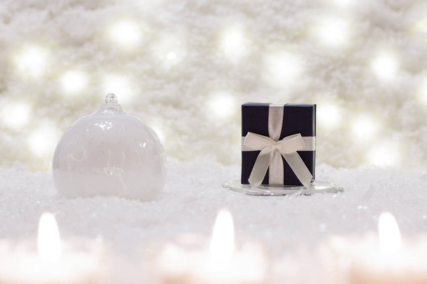 Gift box and glass ball are in the snow.  - Foto, Imagem