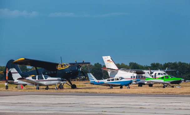 Πέντε μικρά αεροσκάφη δίπλα στο άλλο είναι στο αεροδρόμιο πριν από την απογείωση. - Φωτογραφία, εικόνα