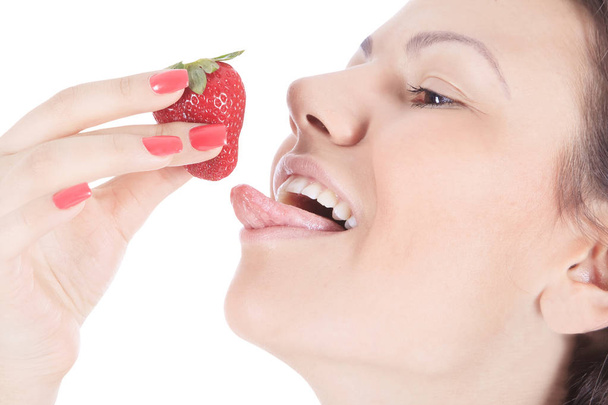 woman with red lips eating a fresh strawberry - Фото, зображення