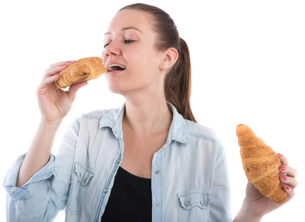 chica joven con un croissant sobre un fondo blanco
 - Foto, Imagen