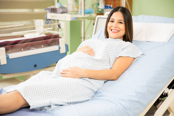 Pregnant woman lying on hospital bed - Foto, afbeelding