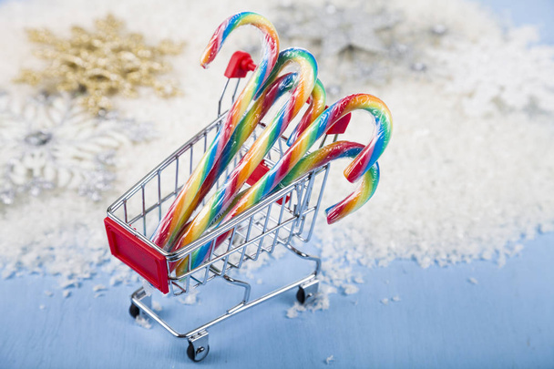 Shopping cart with Christmas candy in the snow. Concept of Chris - Zdjęcie, obraz