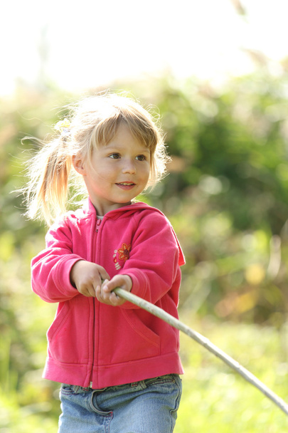 Beautiful little girl outdoors near a lake in rubber boots - Фото, зображення