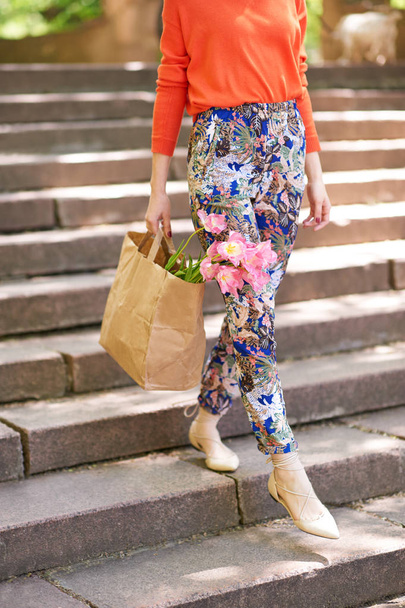 girl holding shopping bag with flowers - Фото, зображення