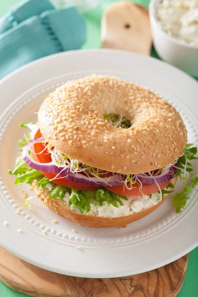 томатний бутерброд на багелі з вершковим сиром цибуля салатний люцерна
 - Фото, зображення