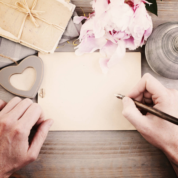 Fundo vintage com mãos masculinas, caneta e papel. Escrita de homem L
 - Foto, Imagem