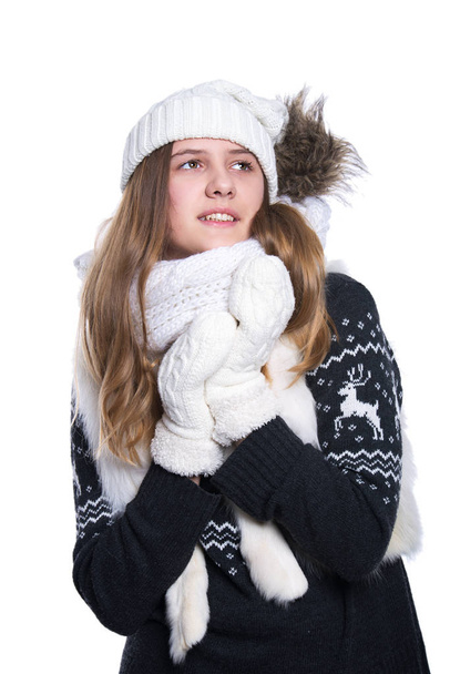 Cute cheerful teenage girl posing in the studio. Showing emotions. Wearing knitted woolen sweater, scarf, hat and mittens. Isolated on white background. Winter clothes. - Фото, зображення