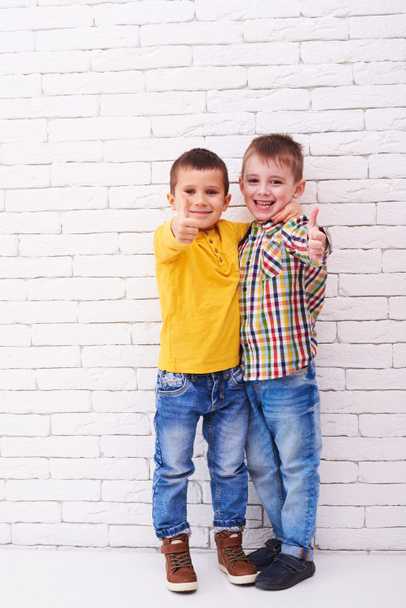 Dwóch chłopców podekscytowany siebie przytulanie i pokazuje kciuk w górę  - Zdjęcie, obraz