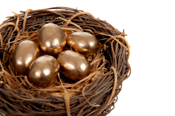 Gold eggs in a nest on a white background - Photo, Image