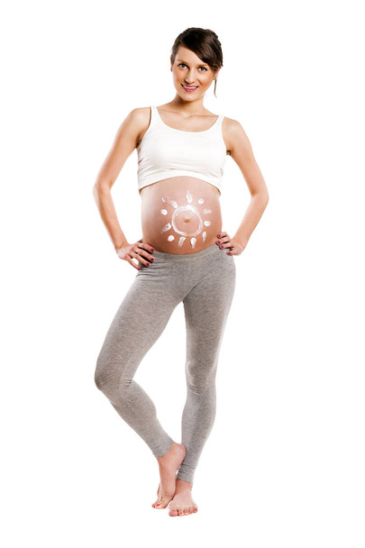 Femme enceinte avec soleil crème sur le ventre, isolée sur le dos blanc
 - Photo, image