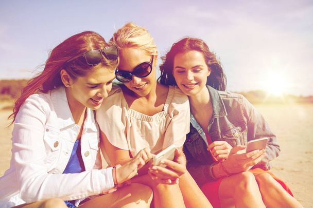 group of happy women with smartphones on beach - Fotoğraf, Görsel