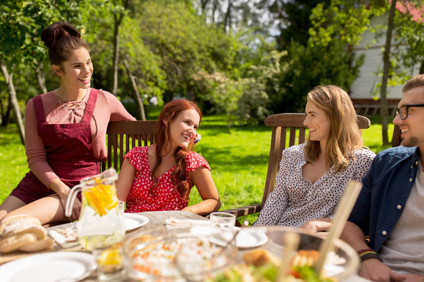 amigos felices cenando en la fiesta del jardín de verano
 - Foto, imagen