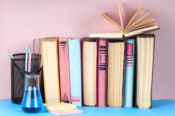Ανοιχτό βιβλίο, στοίβα από πολύχρωμα βιβλία hardback στο φως τραπέζι. Πίσω στο σχολείο. Χώρο αντίγραφο για το κείμενο - Φωτογραφία, εικόνα