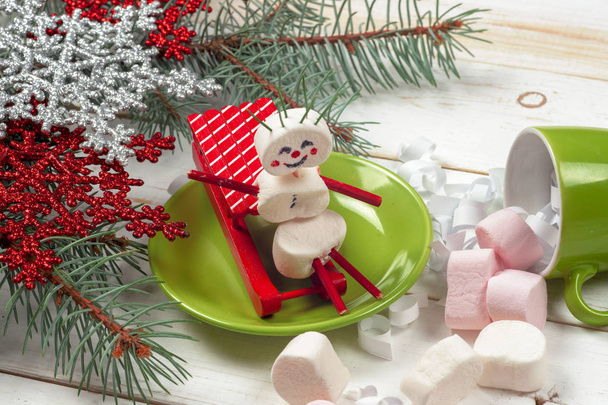 Christmas card with fun marshmallow snowman in green cup, tree - Foto, afbeelding