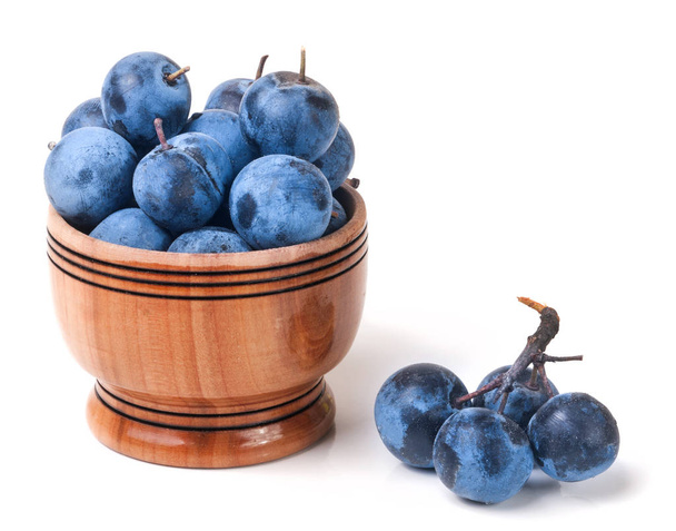 blackthorn berries in a wooden bowl isolated on white background - Photo, Image