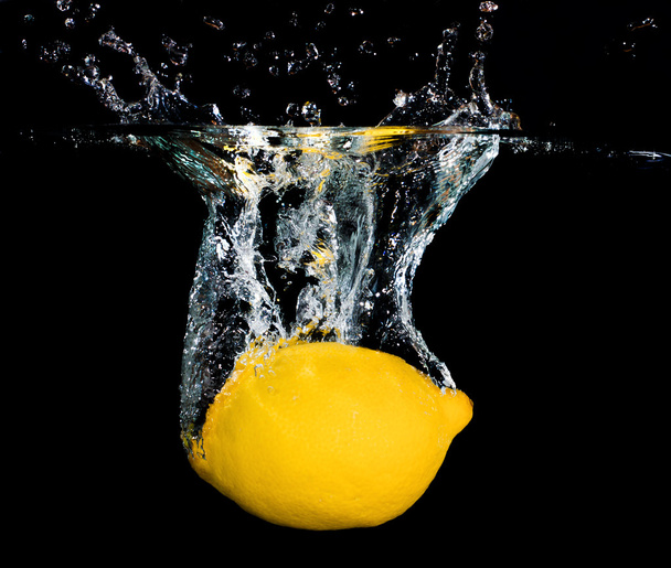 frische Zitrone fällt ins Wasser - Foto, Bild