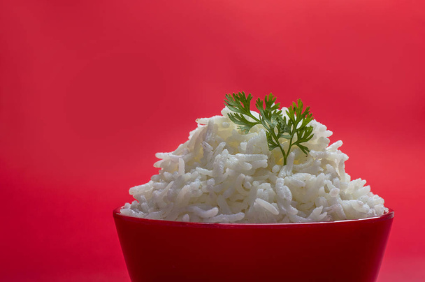 Cooked plain white basmati rice in a red bowl on red background - Foto, Bild