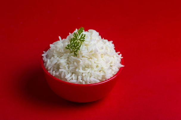 Cooked plain white basmati rice in a red bowl on red background - Foto, imagen