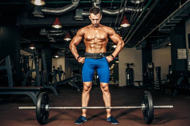Strong Bodybuilder preparing for deadlift of barbell in the gym, - Фото, зображення