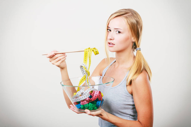 Diet. Girl with colorful measuring tapes in bowl - Fotoğraf, Görsel